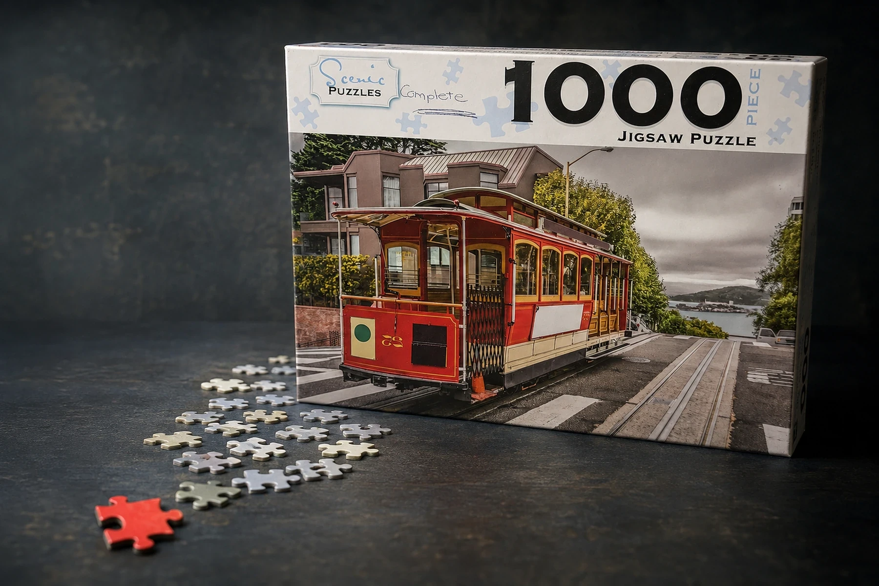 A red jigsaw piece leads through scattered pale pieces towards a Scenic Puzzles box showing a red San Francisco cable car above the bay.