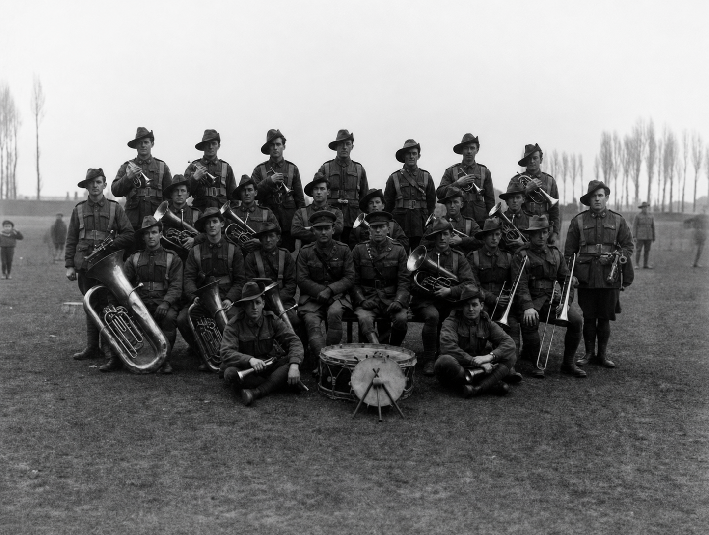 Members of the 9th Battalion band pose outdoors with brass instruments and a drum at Roux in January 1919.