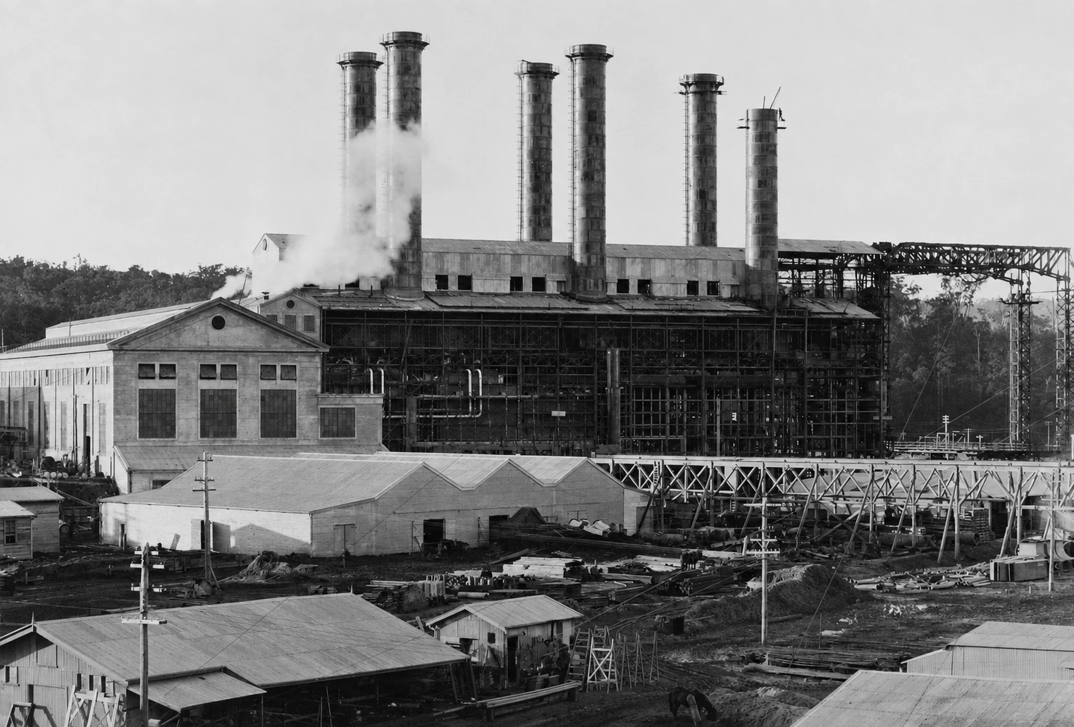 Yallourn's boiler house and turbine house under construction circa 1922, with six chimneys, scaffolding, workshops and building materials across the site.