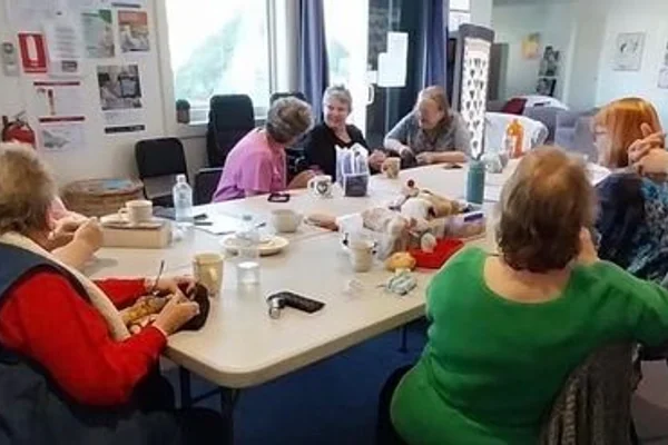 People gathered around a table for a neighbourhood-house activity