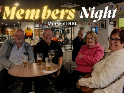 A group of RSL members smiling and sharing drinks at a table under a glowing 'Members Night' sign at Morwell RSL.
