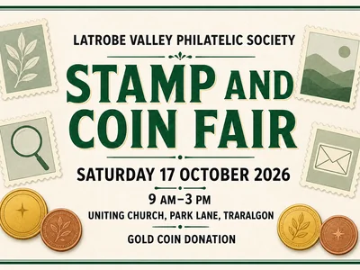 A display table covered with colourful postage stamps and coins at a collectors fair, with visitors browsing nearby.