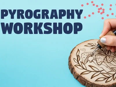 Hands using a pyrography pen to burn an intricate floral and skull design into a round wooden slice.