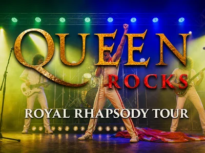 Queen Rocks performers on stage in dramatic lighting, recreating the iconic look and energy of Queen's legendary live concerts.