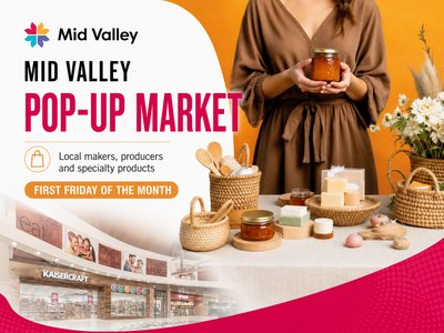 A bustling indoor market with colourful stalls selling fresh produce and handmade crafts inside a shopping centre.