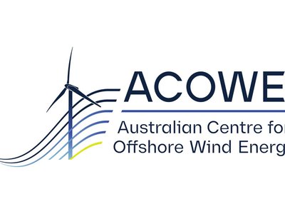 A panel of speakers at an energy industry symposium with offshore wind imagery displayed on a screen behind them.