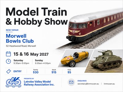Detailed model train layout with miniature locomotives running through a scenic diorama at an indoor hobby show.