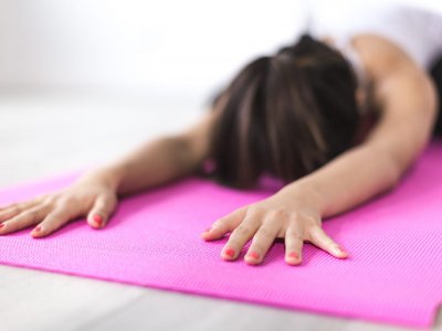 Women participating in a Pilates class together in a community multipurpose room.