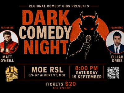 A stand-up comedian performing under a spotlight on a small stage before a laughing audience in a dimly lit venue.