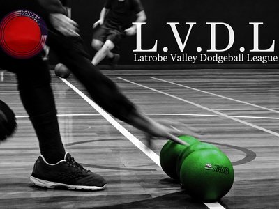 Women laughing and playing dodgeball together inside a regional indoor sports stadium.