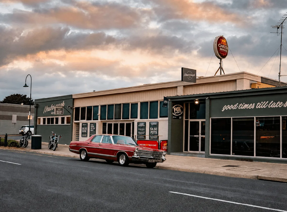 Newborough Hotel exterior at dusk with a red vintage car parked along Monash Road.