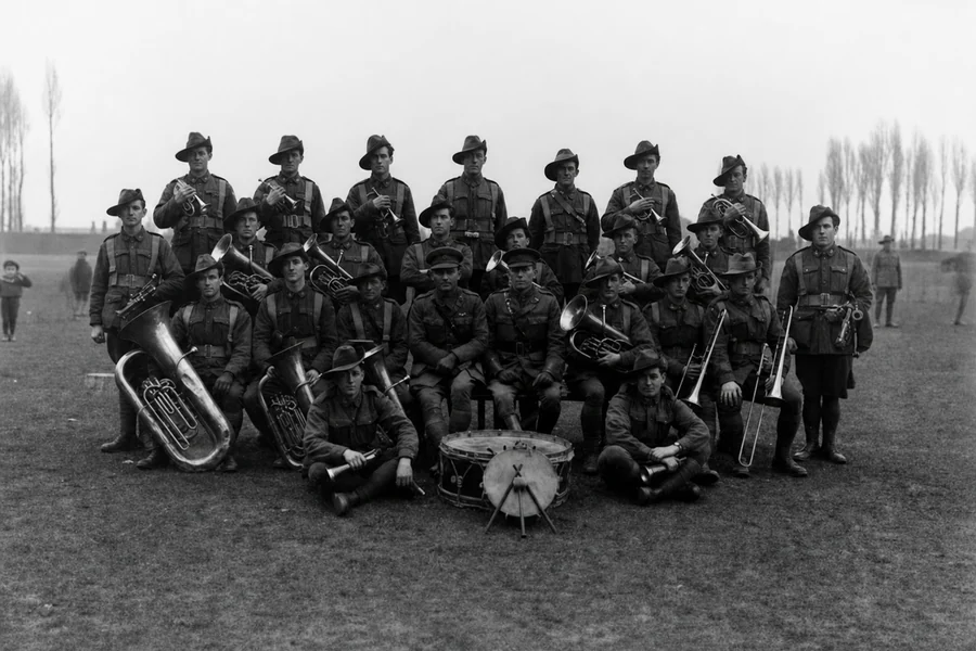 Members of the 9th Battalion band pose outdoors with brass instruments and a drum at Roux in January 1919.
