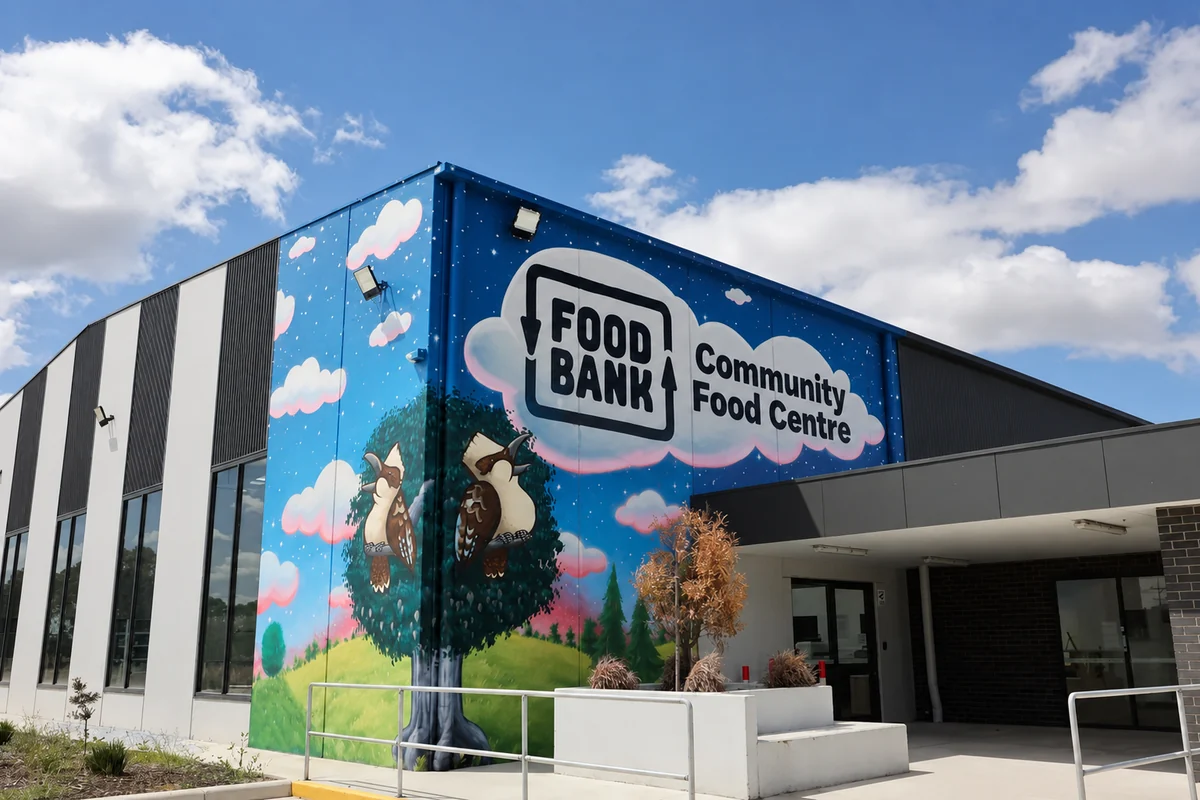 The Foodbank Community Food Centre exterior, with a large blue mural showing two birds in a tree.
