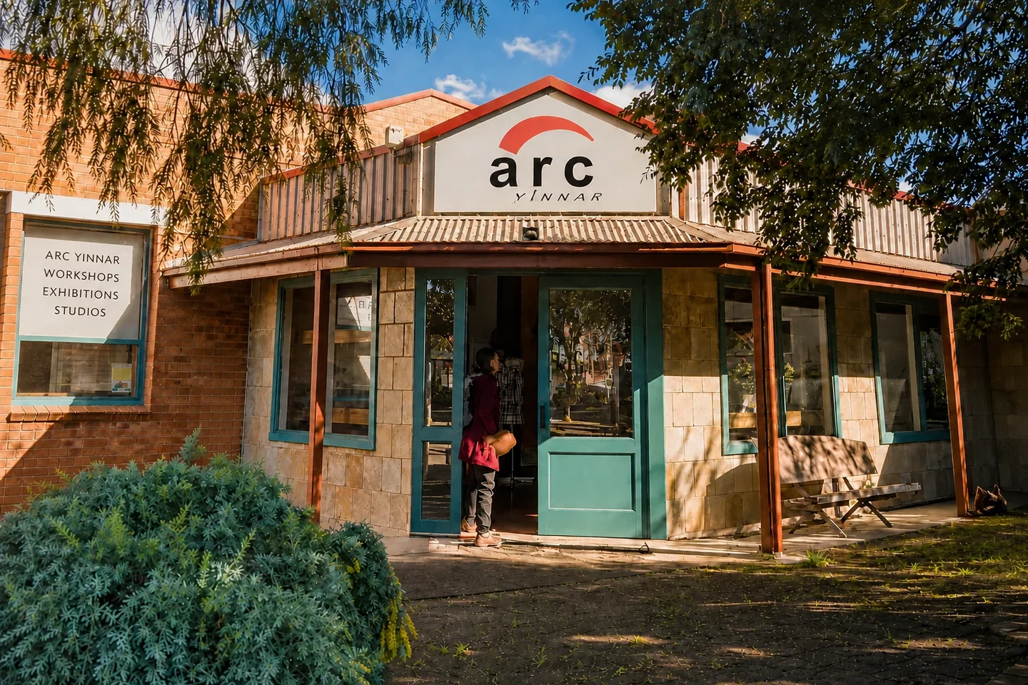 ARC Yinnar's Main Street entrance beneath its complete red, black and white logo, with a window sign for workshops, exhibitions and studios.