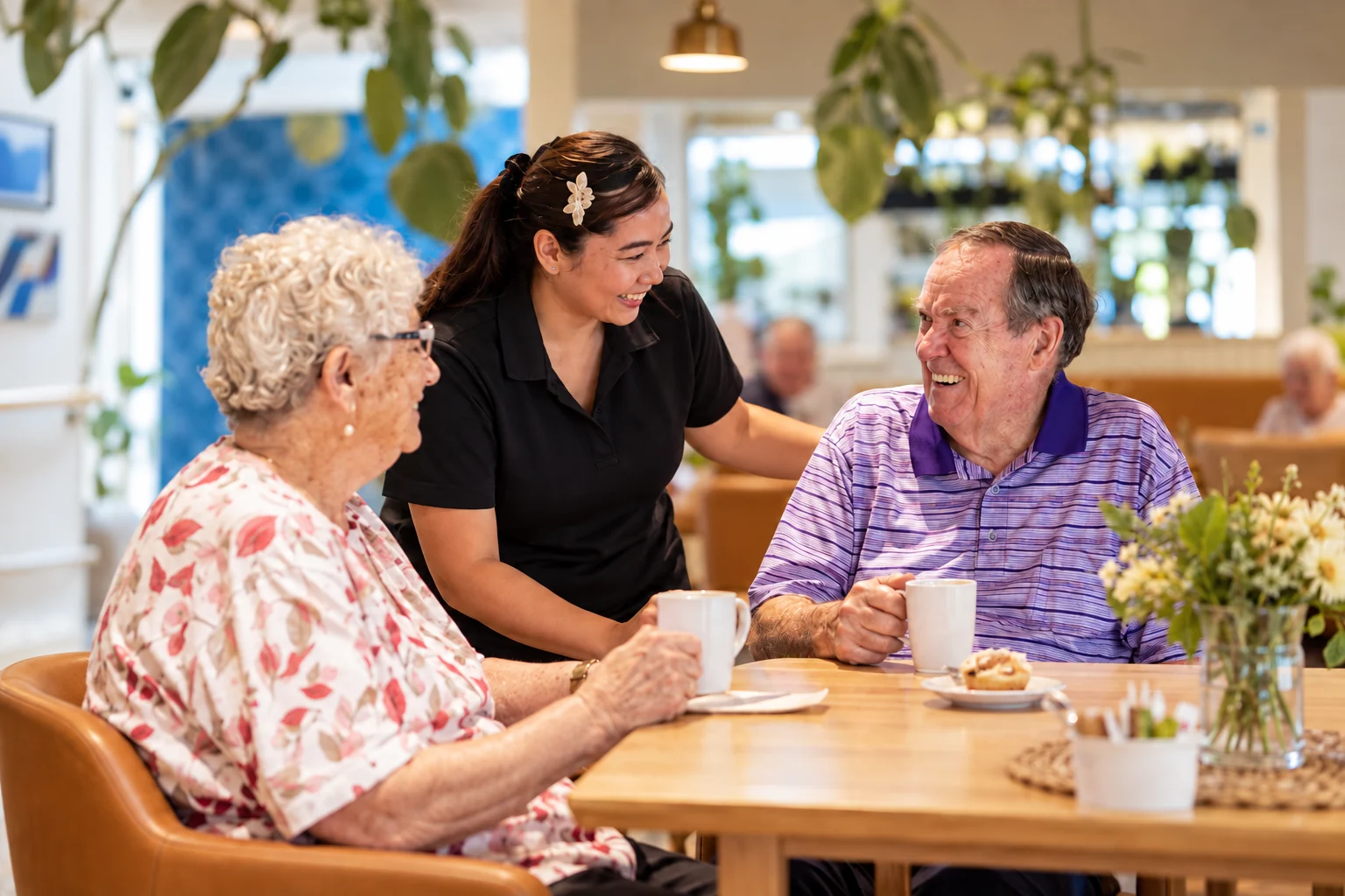 Care worker sharing a warm moment with two older residents