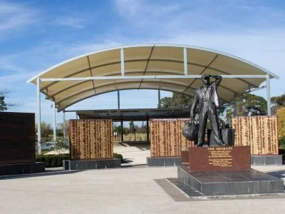 The Wall of Recognition and bronze migrant statue at Gippsland Immigration Park in Morwell.
