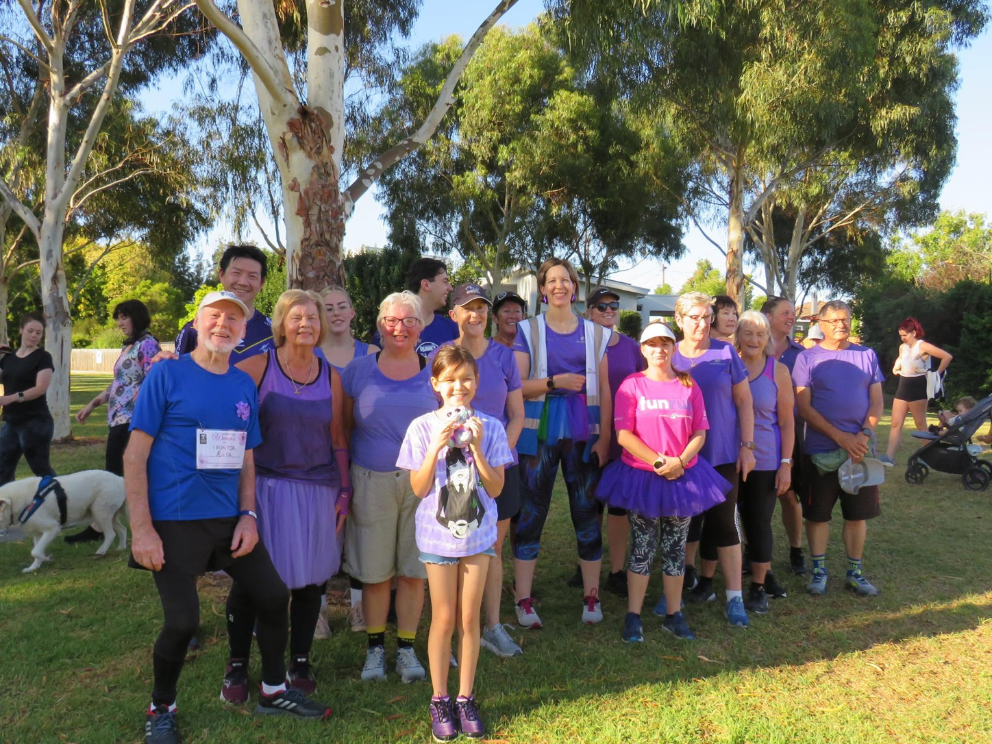 A group of Traralgon parkrun participants standing together beneath gum trees