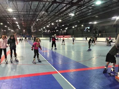 People roller-skating across the indoor rink at Wheelzworld in Stadium 34