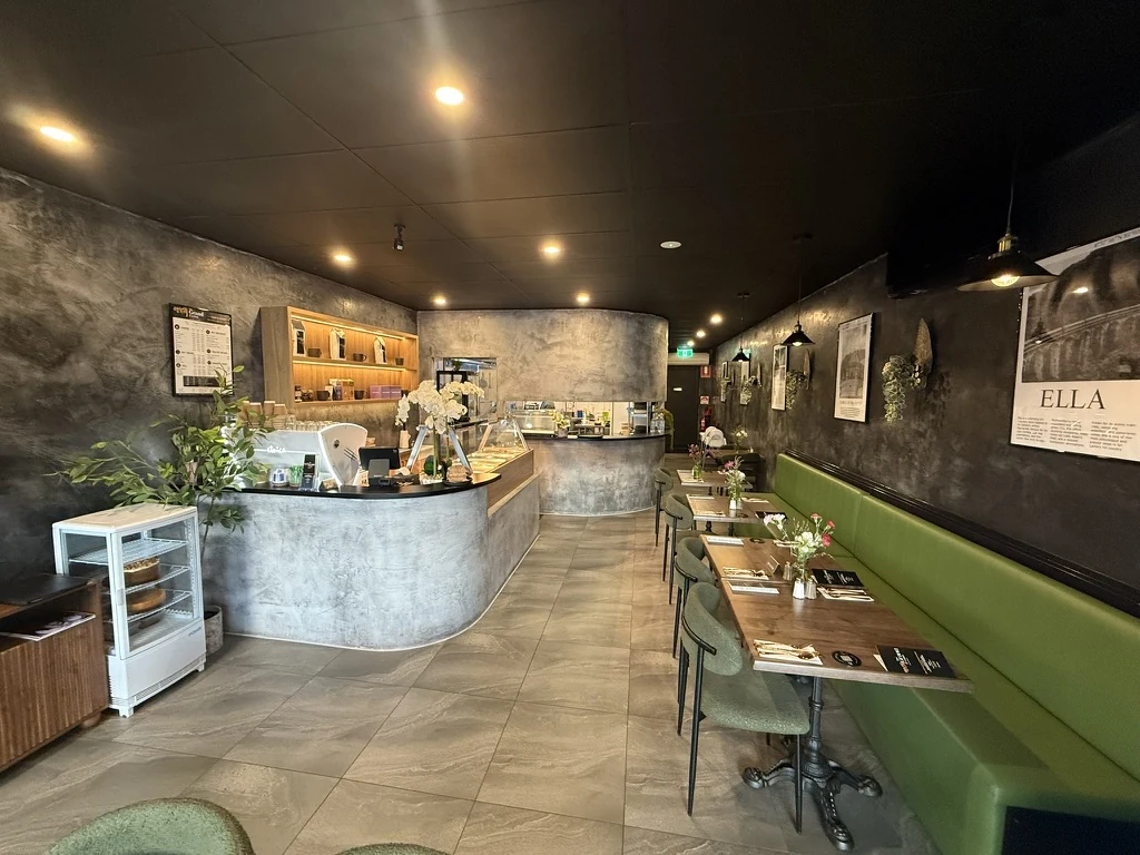 The Grand Ceylon interior, with a curved counter to the left and tables beside green banquette seating to the right.