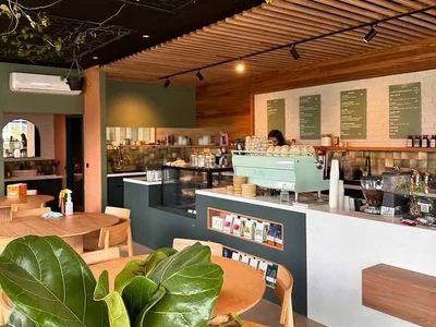 The interior of Finally Mine Coffee House, with green cabinetry, timber details and a pale green coffee machine.