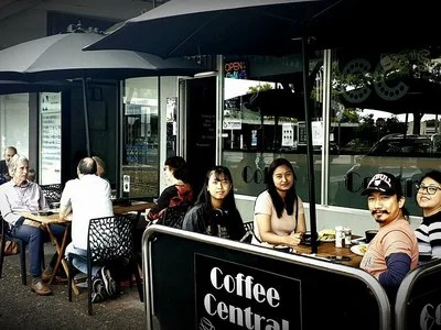 People seated at outdoor tables outside Coffee Central in Moe.