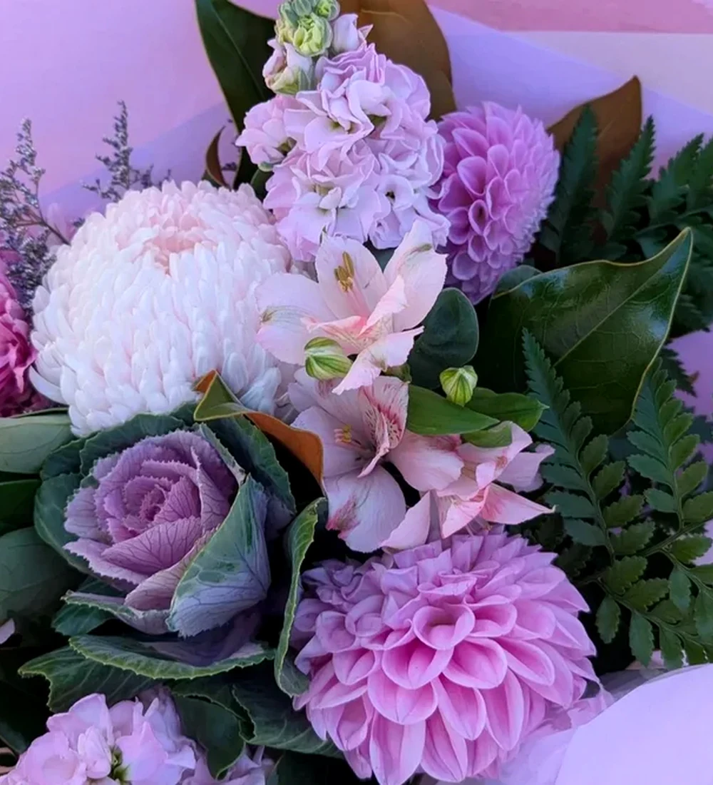 A close arrangement of pink, purple and white flowers with green foliage.