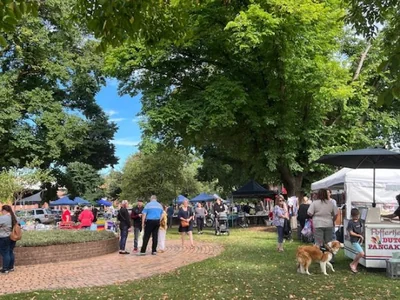 Visitors browse market stalls beneath the trees at Traralgon Craft Market.