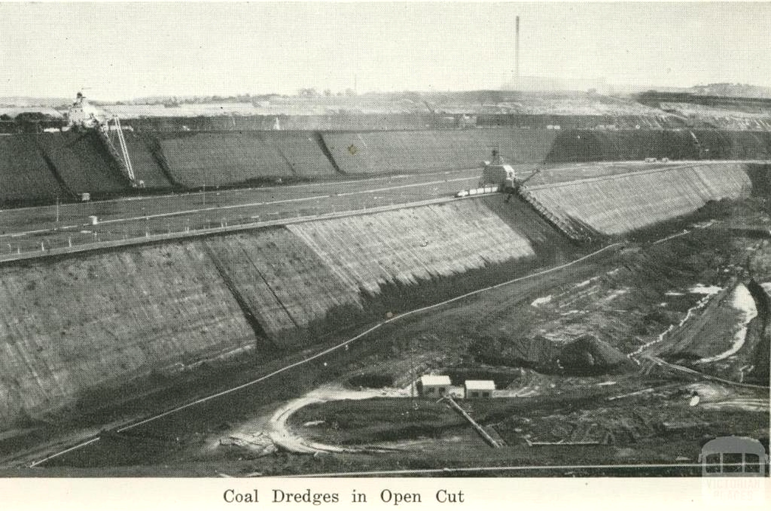 Historic black-and-white photograph of coal dredges working in a terraced open cut.