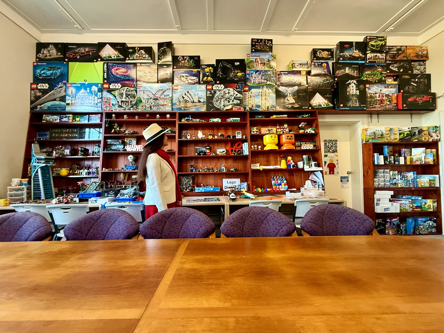 Visitor viewing shelves filled with colourful LEGO models and collections.