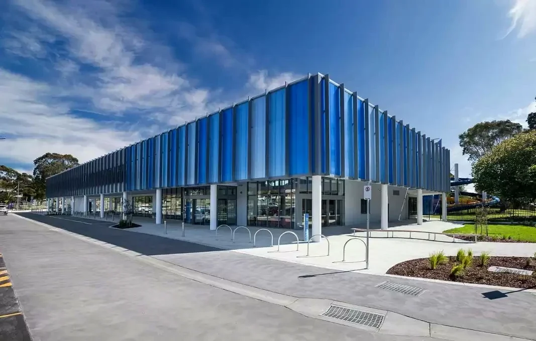 Blue vertical fins wrap the street-facing exterior of Gippsland Regional Aquatic Centre.