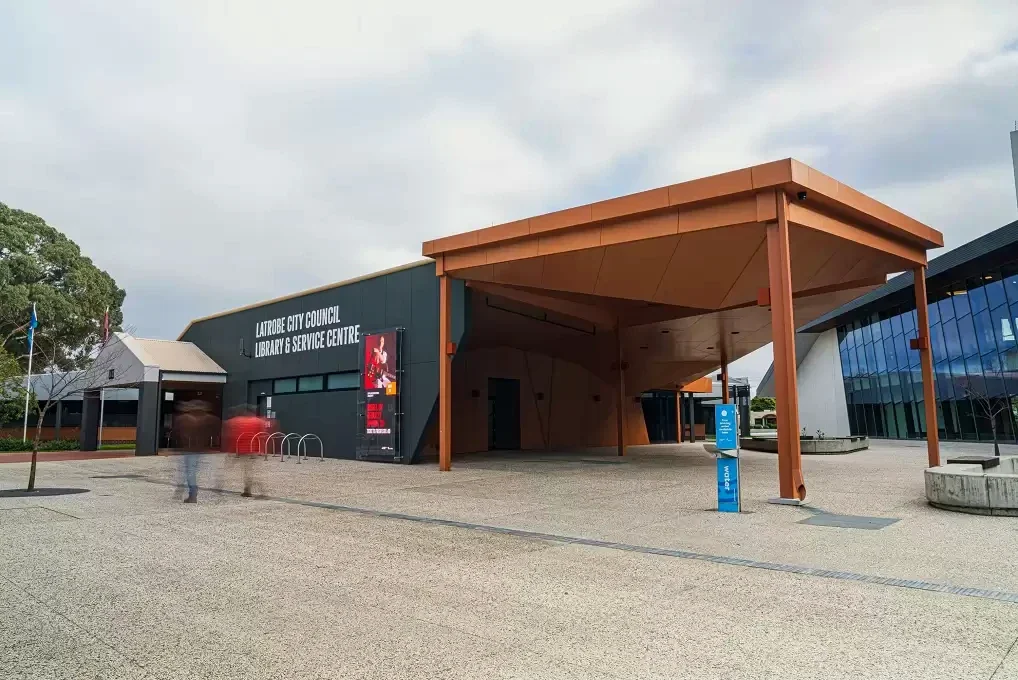 The dark façade and broad copper-coloured canopy mark Traralgon Library and Service Centre.