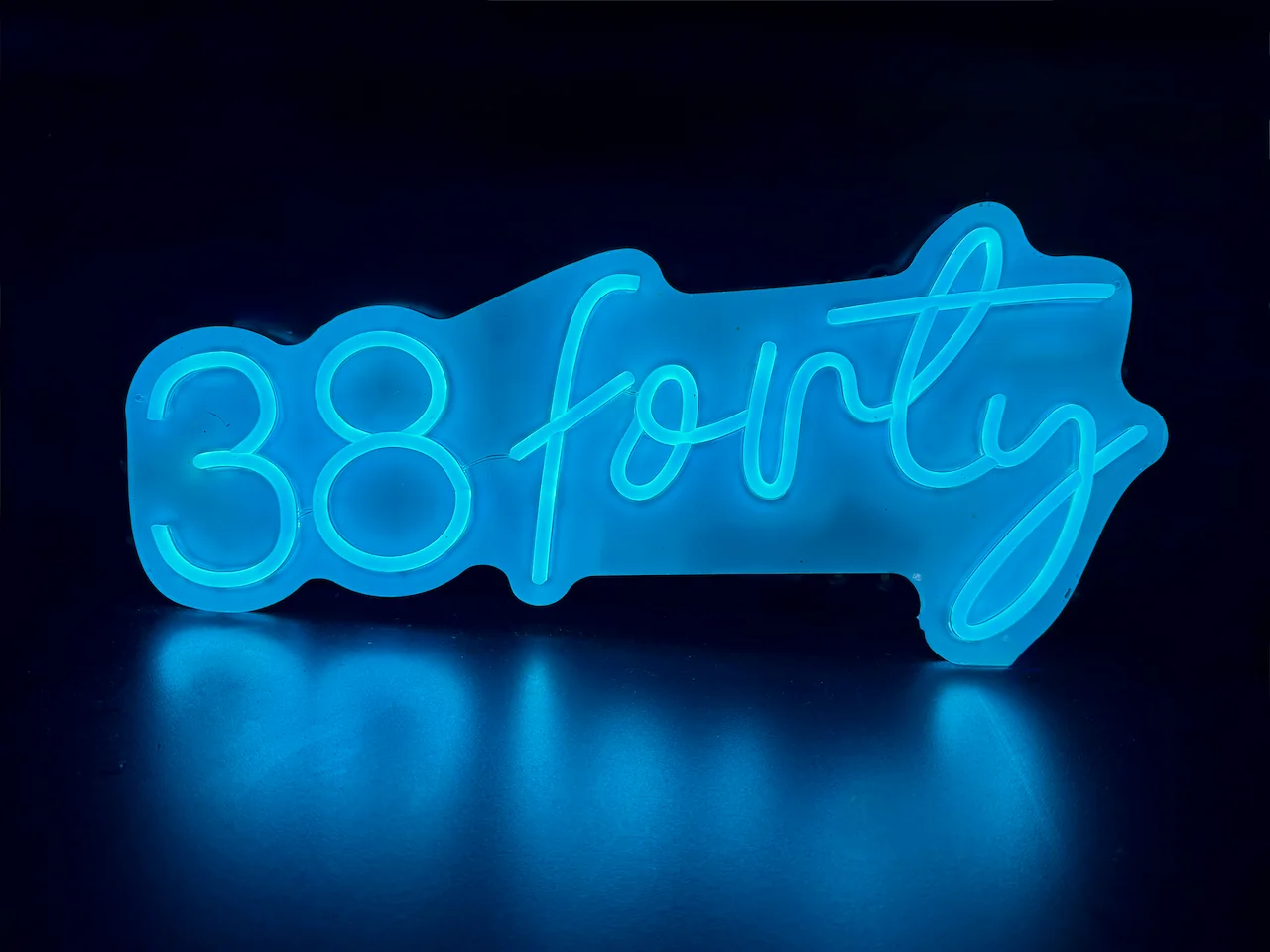 The illuminated blue 38forty sign inside the cafe