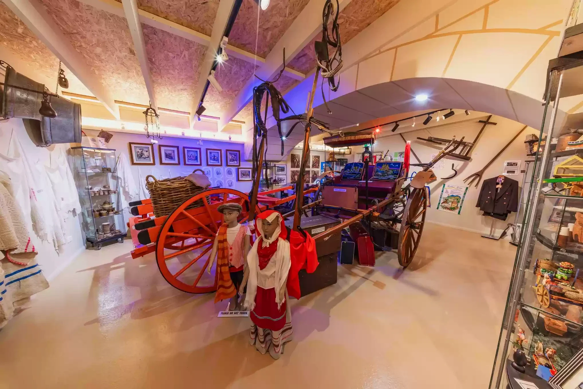 A horse-drawn cart, traditional clothing and tools form a working-life display inside the Maltese Museum.