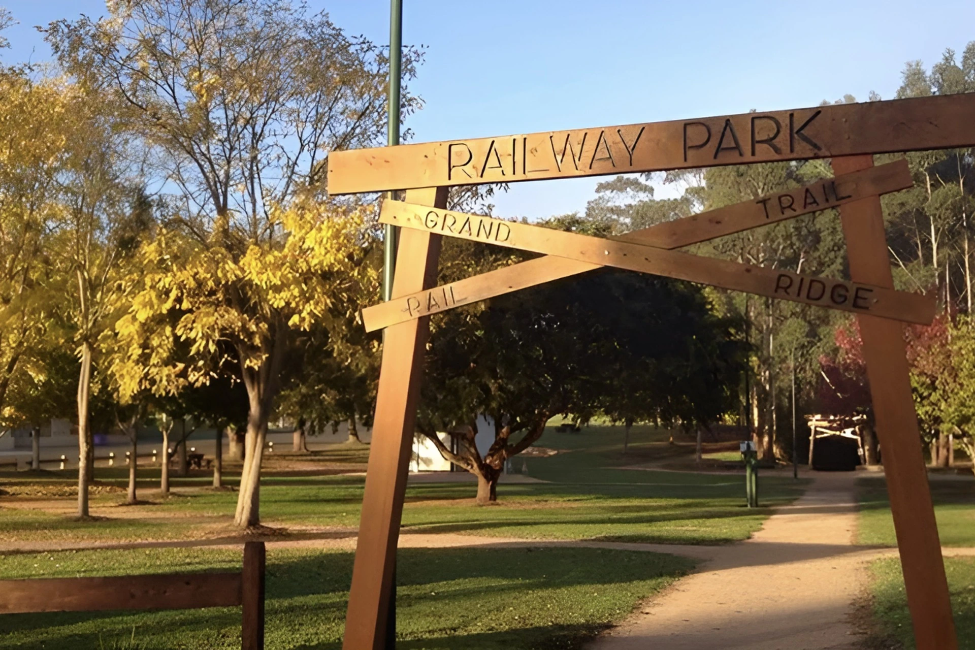 The timber Railway Park sign at Boolarra among autumn trees