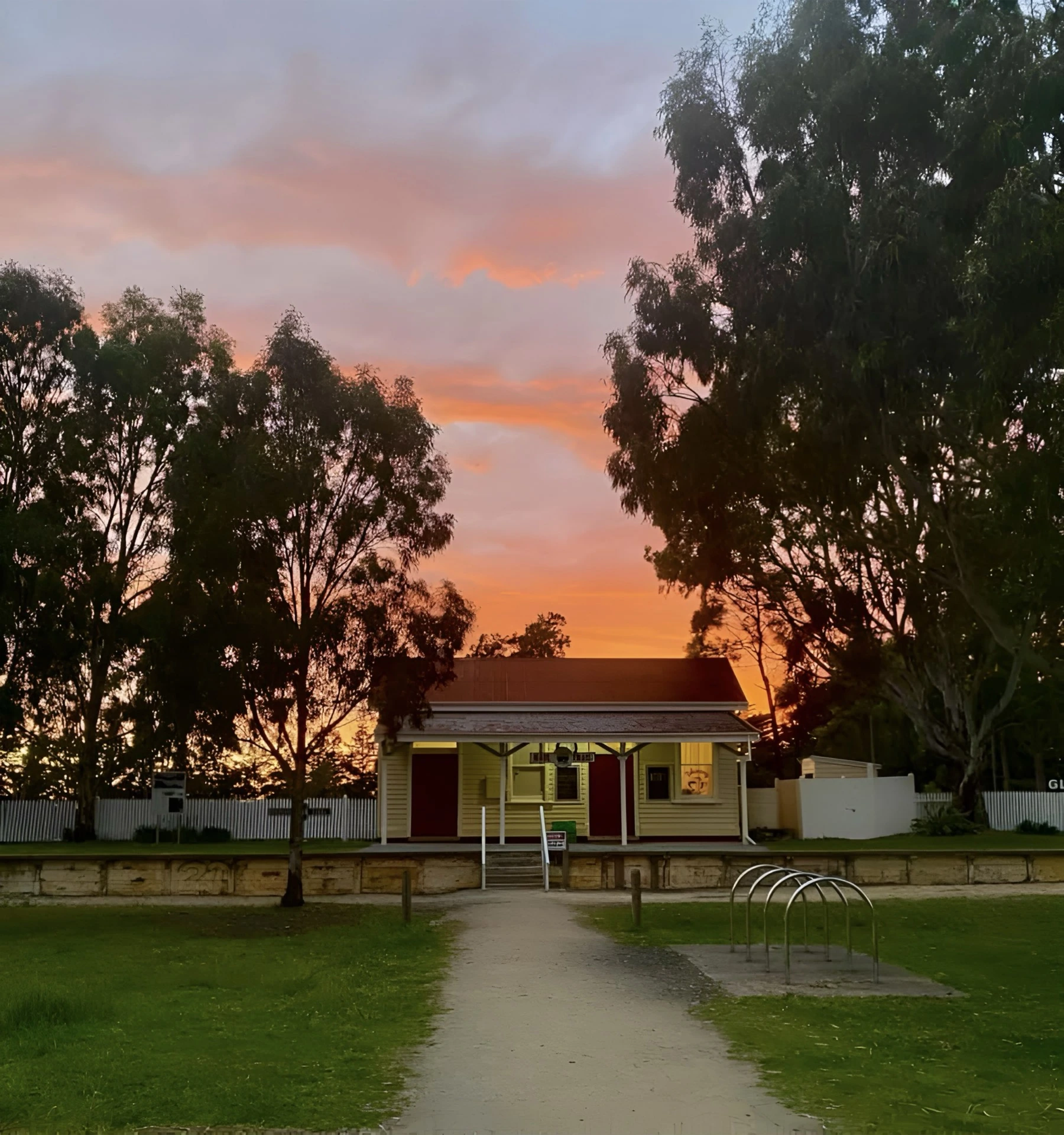 The heritage railway building at Glengarry beneath a vivid orange evening sky